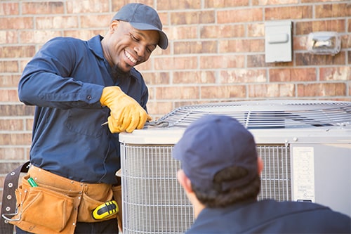 workers performing maintenance on an HVAC unit